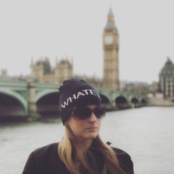 Beautiful young woman standing against thames river and big ben