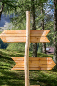 Close-up of wooden sign on field in forest