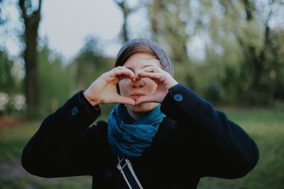 Portrait of cute girl forming heart from hands