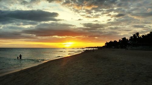 Silhouette man on beach against sky during sunset