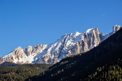 Scenic view of snowcapped mountains against clear blue sky