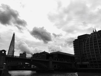 Tower bridge over river against sky in city