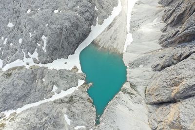 High angle view of rocks in lake during winter