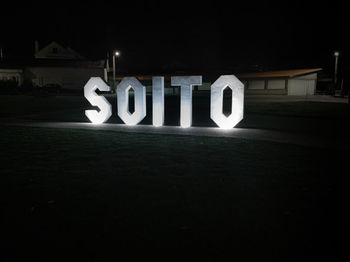 Text on illuminated sign at night