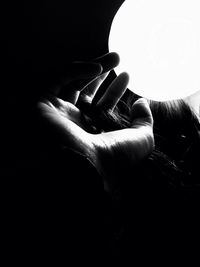 Cropped image of hand holding over black background