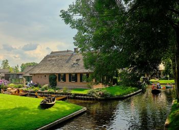 Building by lake against sky