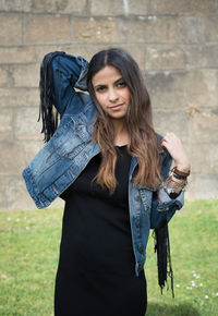 Portrait of beautiful woman standing against wall