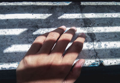 High angle view of woman shadow on hand
