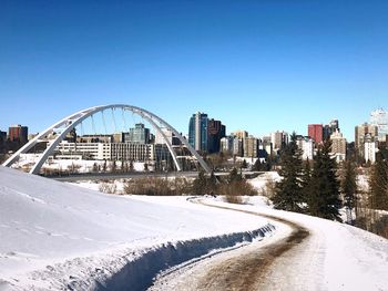 View of buildings in city against clear blue sky