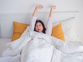 Young woman lying on bed at home