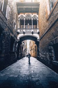 Rear view of man walking amidst buildings