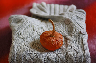 High angle view of pumpkin by sweater on table