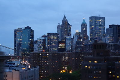 Illuminated cityscape against sky at dusk