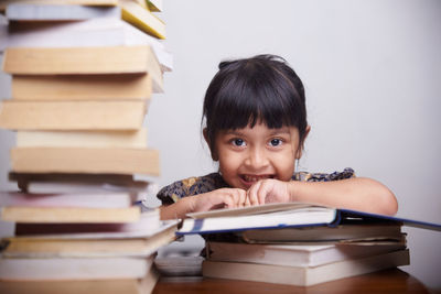 Portrait of girl sitting on book