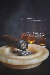 Cigar and ashtray with whiskey glass