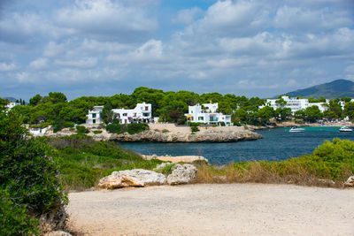 Houses at seaside against cloudy sky