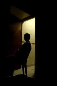 Silhouette boy standing at home