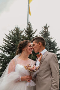 Groom hug and kiss bride in palm grove. wedding day for two. lovely weeding couple. young lovers.