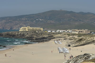 Hotel fortaleza do guincho on rock formation by beach against sky