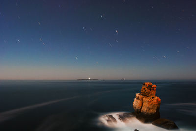 Scenic view of sea against clear blue sky at night