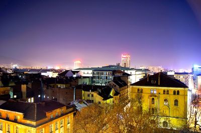 View of illuminated cityscape against blue sky