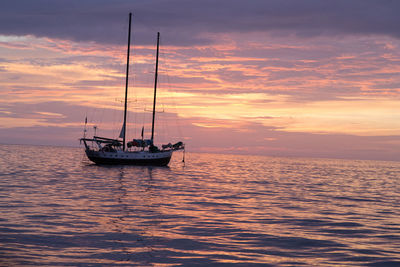 Boat sailing in sea at sunset