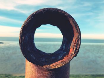 Close-up of wooden post on beach against sky