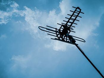 Low angle view of silhouette cranes against sky