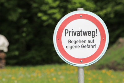 Close-up of road sign against trees