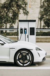 Electric car charging at station on city street