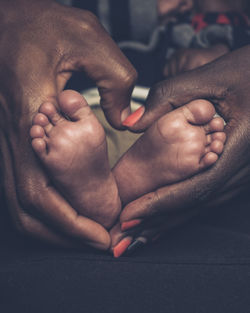 Cropped image of man holding hands   with baby feet