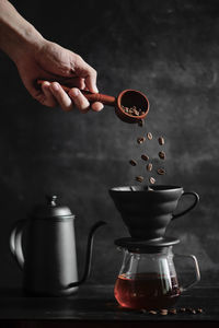 Cropped image of hand pouring coffee cup