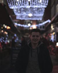 Portrait of young man in city at night