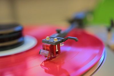 Close-up of red record spinning on turntable