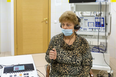 Audiologist checks the hearing of an older woman