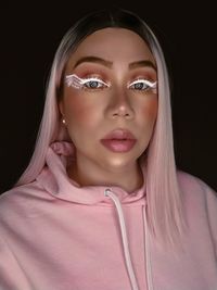 Portrait of a beautiful young woman over black background