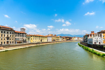 Canal amidst buildings in city against sky