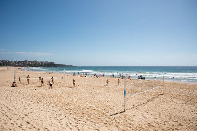 Group of people at beach against sky