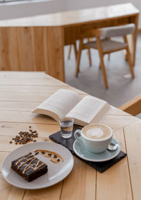 White coffee mug lay on wooden background.