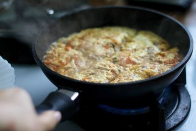 Close-up of person preparing food in pan