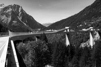 Bridge over mountain against sky