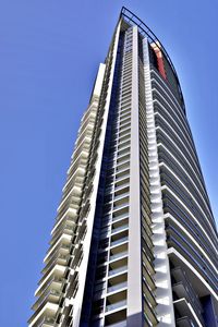 Low angle view of modern building against clear blue sky