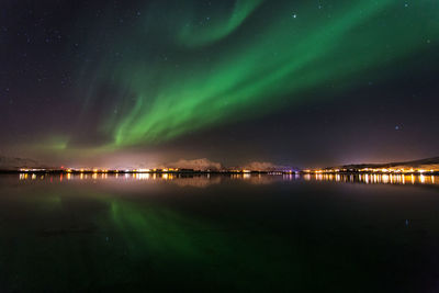 Scenic view of sea against aurora borealis at night