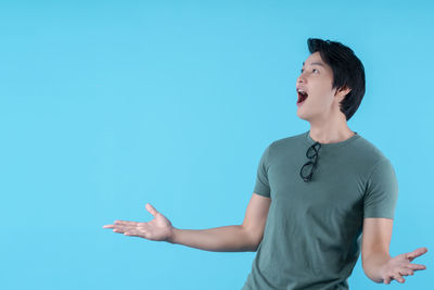 Full length of man standing against blue background