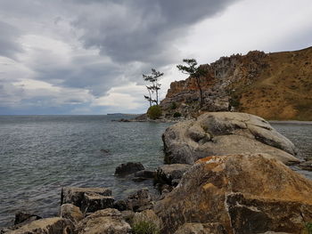 Rock formation on beach against sky