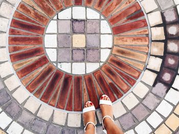 Low section of woman standing on tiled floor