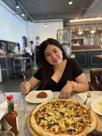 Portrait of a smiling young woman in restaurant