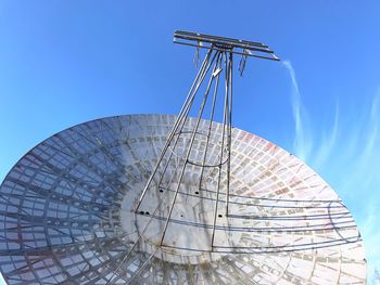 Low angle view of ferris wheel against blue sky