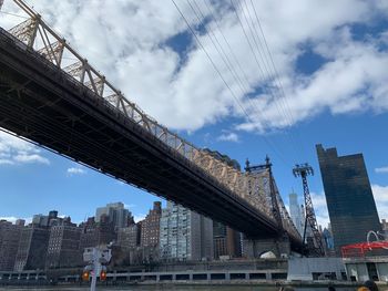 Low angle view of bridge and buildings against sky