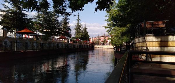 Canal by buildings against sky in city